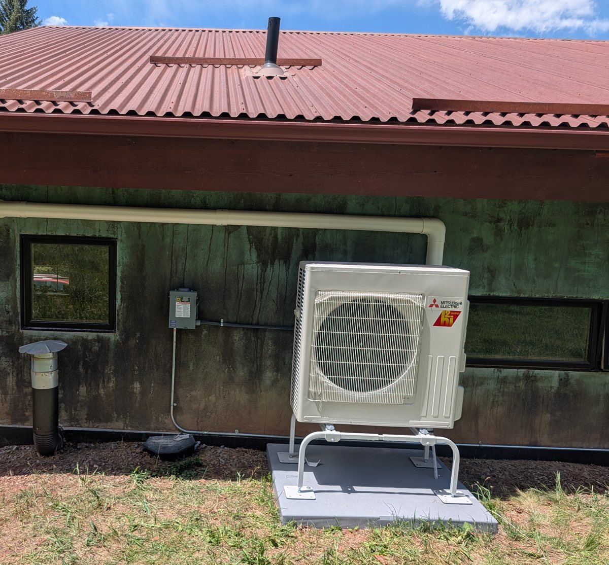 Mitsubishi heat pump with disconnect and conduit installed on a mountain home